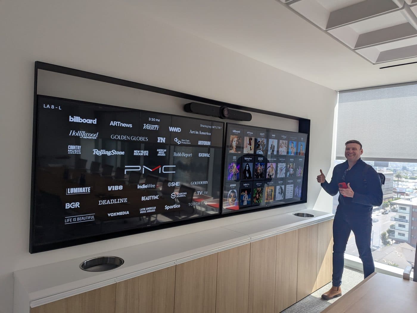 Alex Ford standing beside a large wall screen, mid-presentation