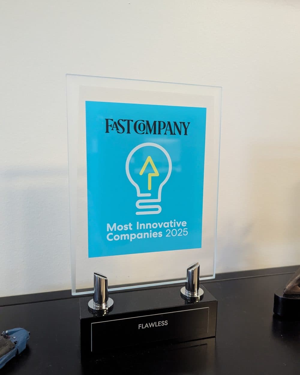 A Fast Company "Most Innovative Companies 2025" award standing on a desk, engraved Flawless