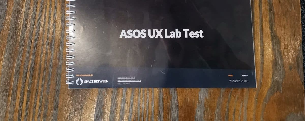 A spiral-bound report titled "ASOS UX Lab Test" on a wooden desk